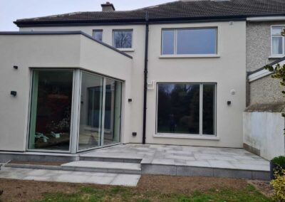 Contemporary rear home extension with full-height corner glazing and newly installed granite patio steps