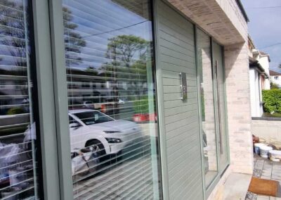 Large modern sliding doors with integrated blinds installed in a light brick facadeConstruction"