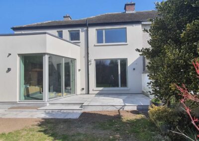 Modern rear house extension with full-height corner glazing, new patio steps and freshly rendered exterior