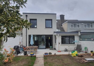 Contemporary rear house extension with large black-framed sliding doors, upgraded patio area, and modern insulated facade